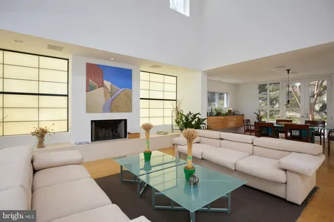 a living room with furniture a fireplace and a large window