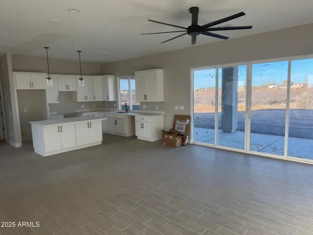 a large white kitchen with a large window appliances and furniture