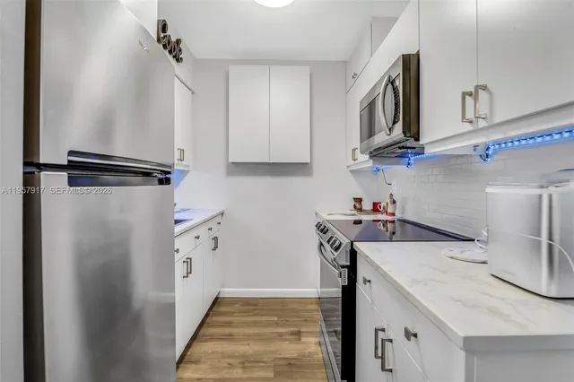 a kitchen with stainless steel appliances granite countertop a sink and a stove