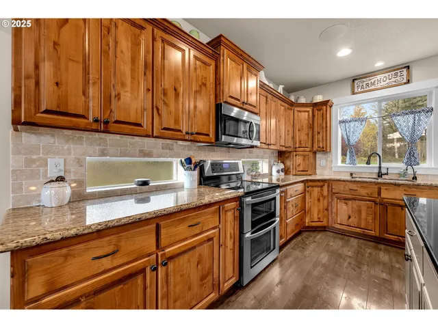 a kitchen with granite countertop stainless steel appliances a sink dishwasher window and cabinets