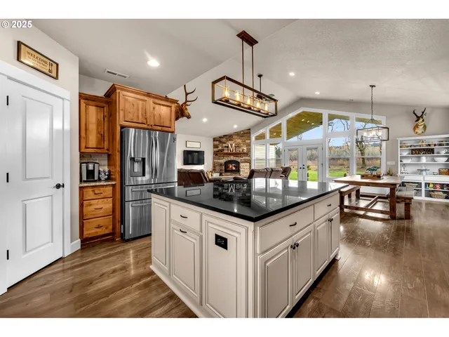 a kitchen with stainless steel appliances kitchen island granite countertop a stove and a large cabinets
