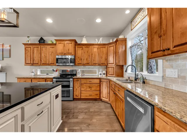 a kitchen with stainless steel appliances granite countertop a sink a stove and cabinets