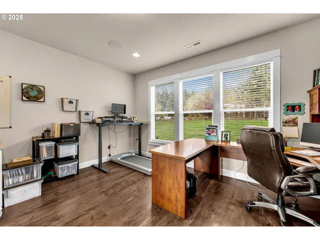 a view of a workspace with furniture and a window