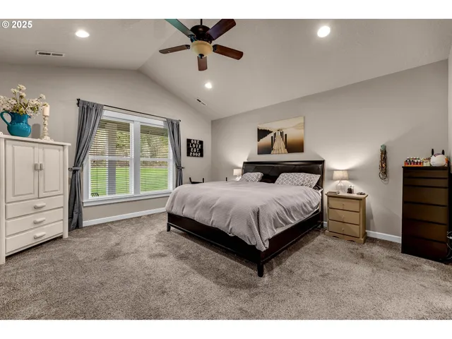 a spacious bedroom with a bed and a ceiling fan