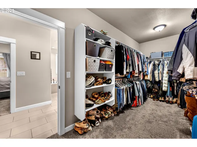 a view of walk in closet with clothes and shoes