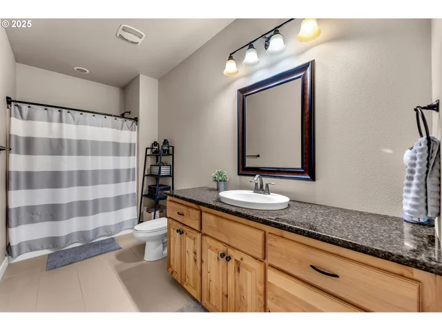 a bathroom with a sink a toilet a mirror and shower