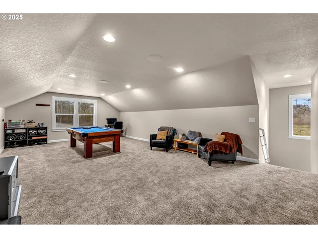 a living room with furniture and a pool table