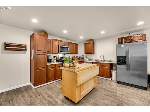 a kitchen with refrigerator a microwave and wooden floor