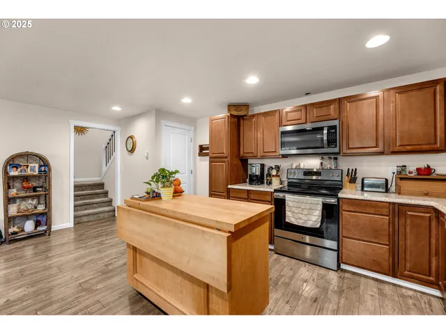 a kitchen with stainless steel appliances kitchen island granite countertop a refrigerator sink and cabinets