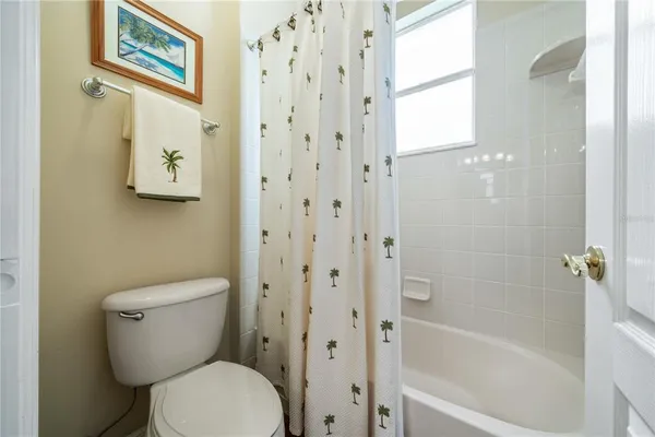 a white toilet sitting next to a bath tub
