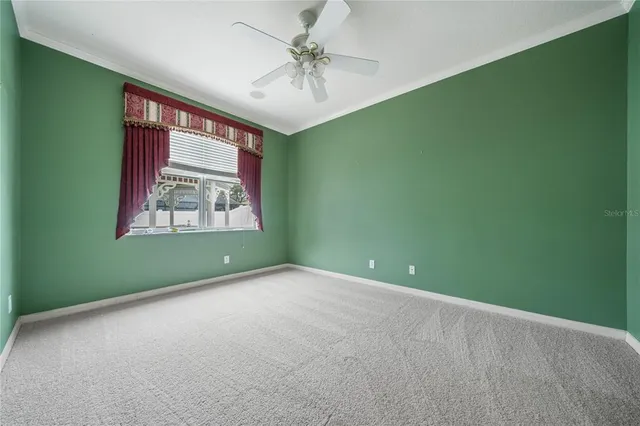 an empty room with windows and a ceiling fan