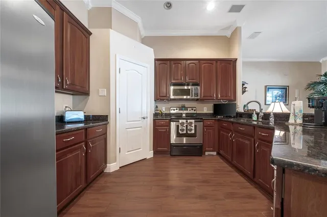 a kitchen with stainless steel appliances granite countertop a refrigerator stove and sink