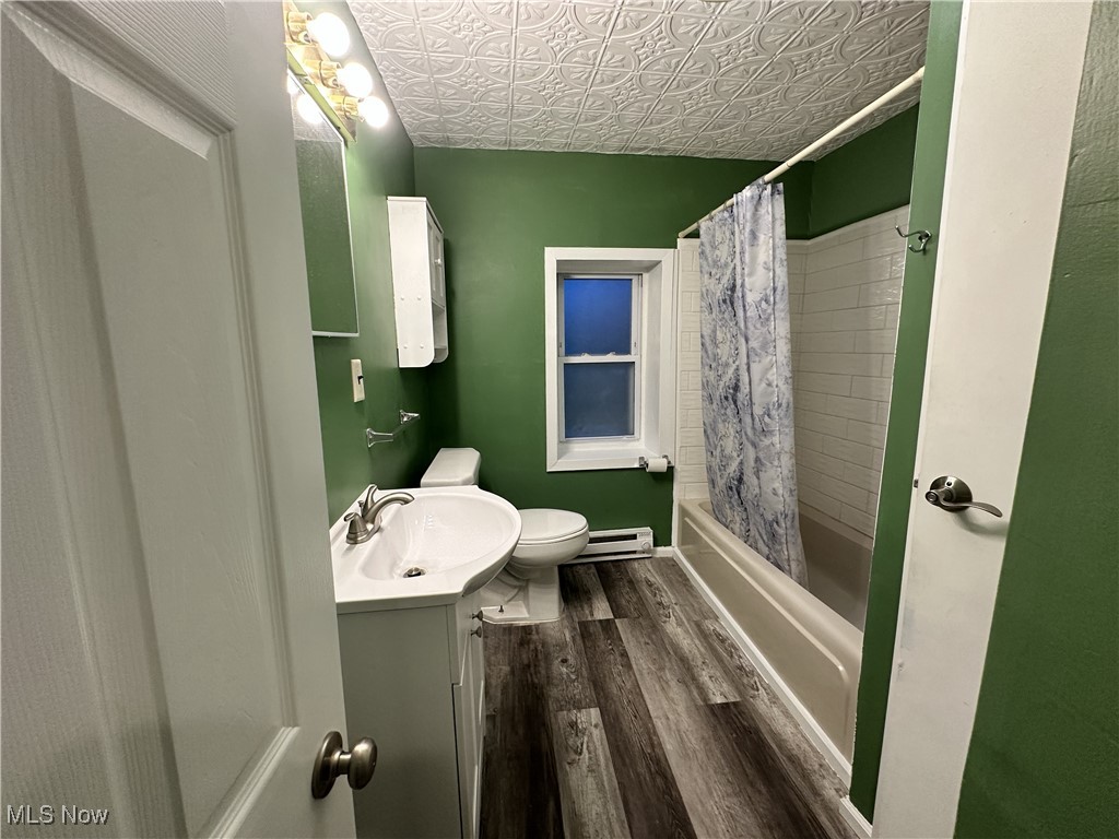 7700 Center Road Ashtabula, OH 44004 - Photo 17 of 31 Full bathroom featuring vanity, toilet, an ornate ceiling, wood finished floors, and shower / bath combination with curtain