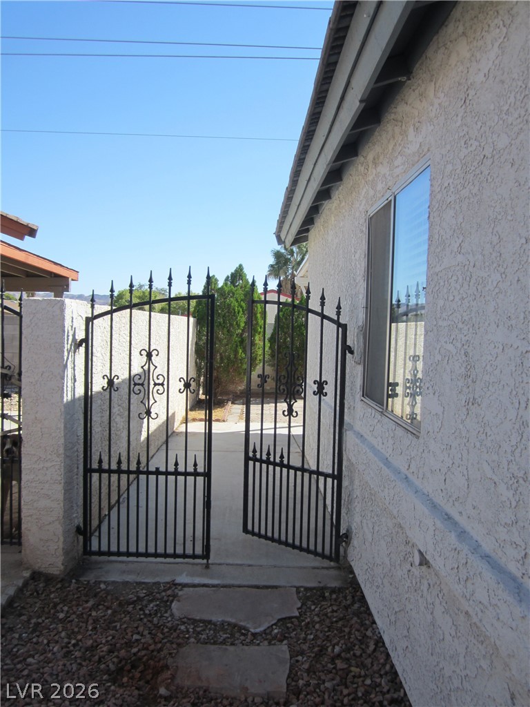 2882 Sandyfalls Way Las Vegas, NV 89142 - Photo 16 of 18 Wrought iron gate opens to a pathway alongside the home, offering both privacy and access.