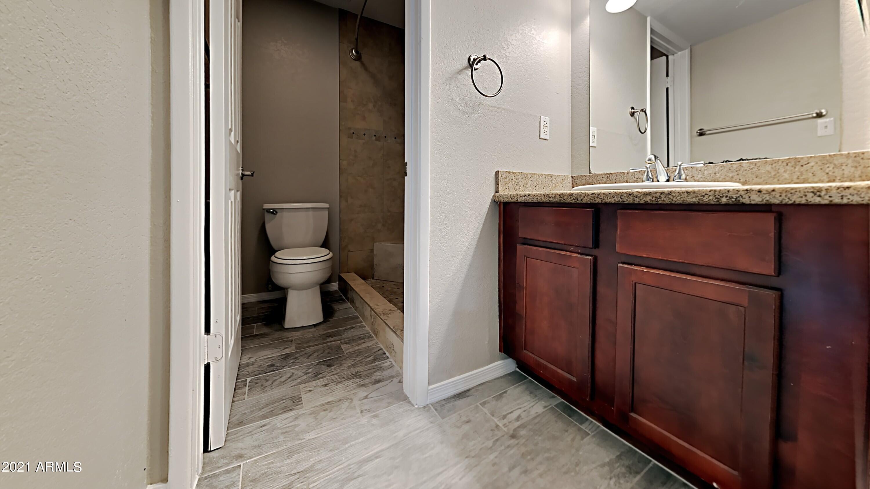 3500 North Hayden Road, Unit 1703 Scottsdale, AZ 85251 - Photo 7 of 8 a bathroom with a granite countertop sink a toilet and a mirror