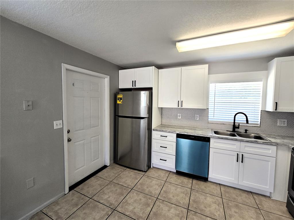5422 Amy Lane New Port Richey, FL 34652 - Photo 11 of 25 a kitchen with white cabinets and appliances
