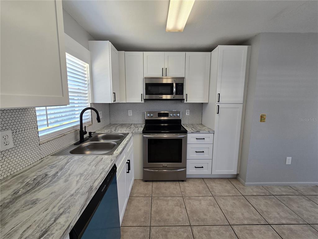 5422 Amy Lane New Port Richey, FL 34652 - Photo 12 of 25 a kitchen with a sink stove and cabinets