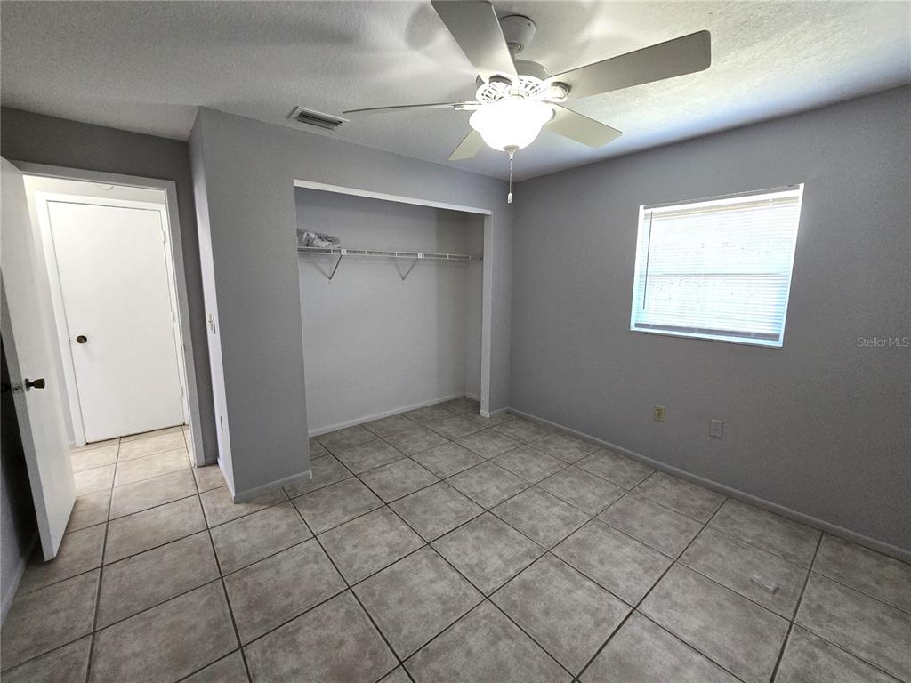 5422 Amy Lane New Port Richey, FL 34652 - Photo 21 of 25 an empty room with fan and windows