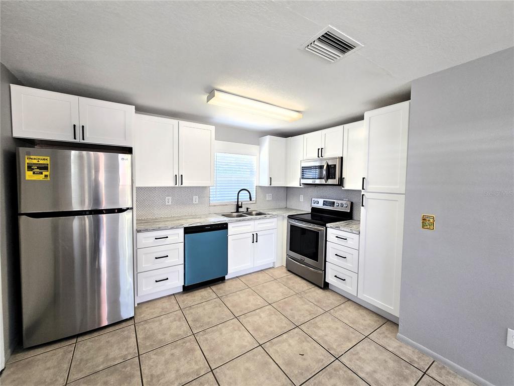 5422 Amy Lane New Port Richey, FL 34652 - Photo 9 of 25 a kitchen with granite countertop cabinets and steel stainless steel appliances