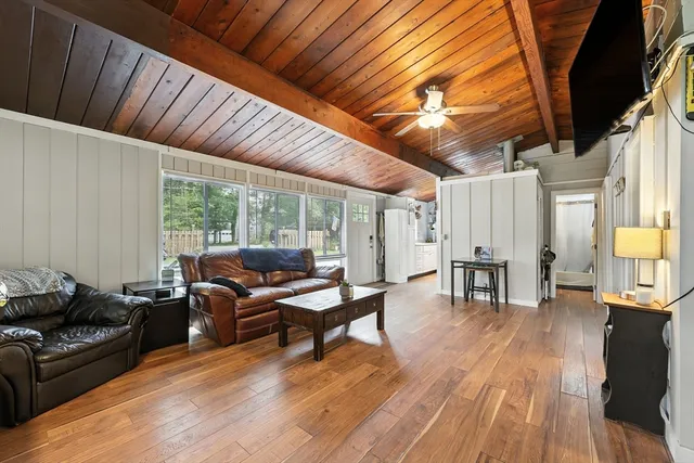 a living room with furniture a wooden floor and next to a window
