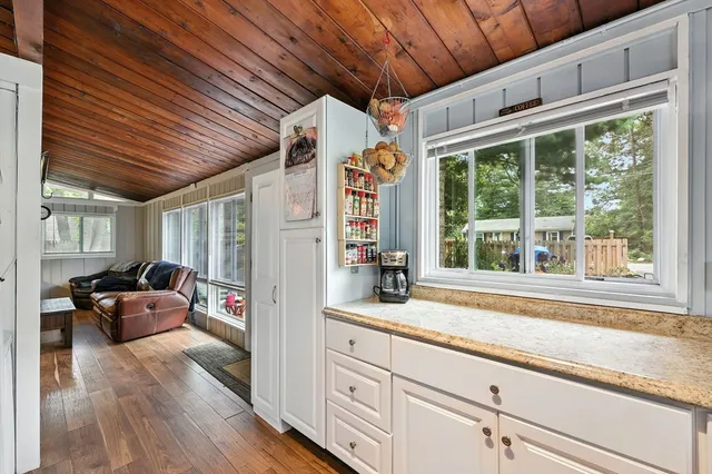 a open kitchen with granite countertop wooden cabinets a sink and a window
