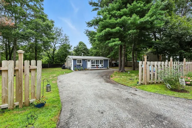 a view of house with backyard and trees
