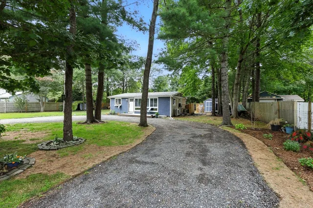 a view of a house with backyard and a tree