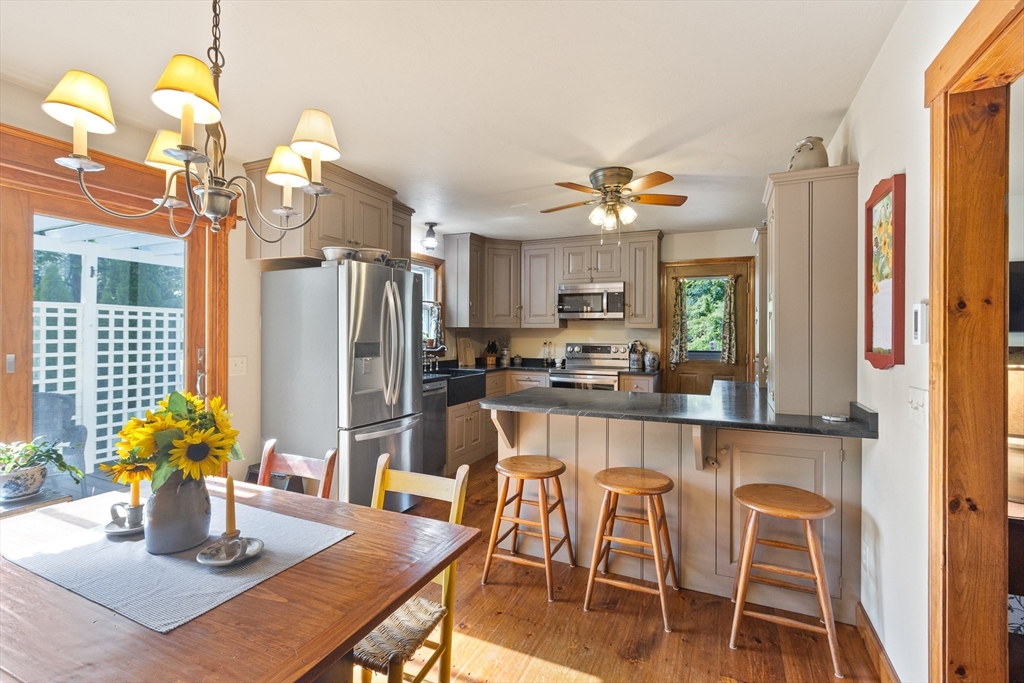 298 Torrey Road Southbridge, MA 01550 - Photo 8 of 40 a kitchen with stainless steel appliances granite countertop a dining table chairs and chandelier