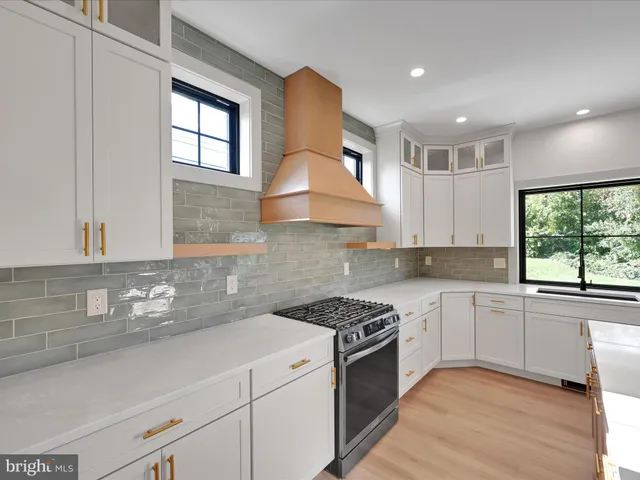 a kitchen with granite countertop a sink stainless steel appliances and window