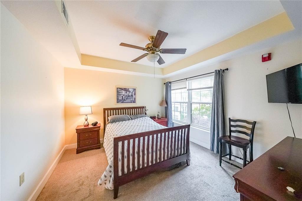 230 East Ponce De Leon Avenue, Unit 327 Decatur, GA 30030 - Photo 11 of 24 a bedroom with a bed and a chandelier