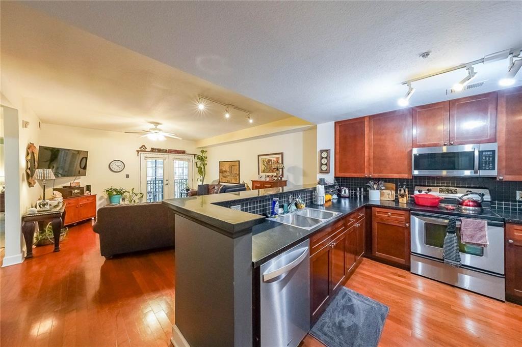 230 East Ponce De Leon Avenue, Unit 327 Decatur, GA 30030 - Photo 4 of 24 a kitchen with stainless steel appliances granite countertop a stove and a refrigerator