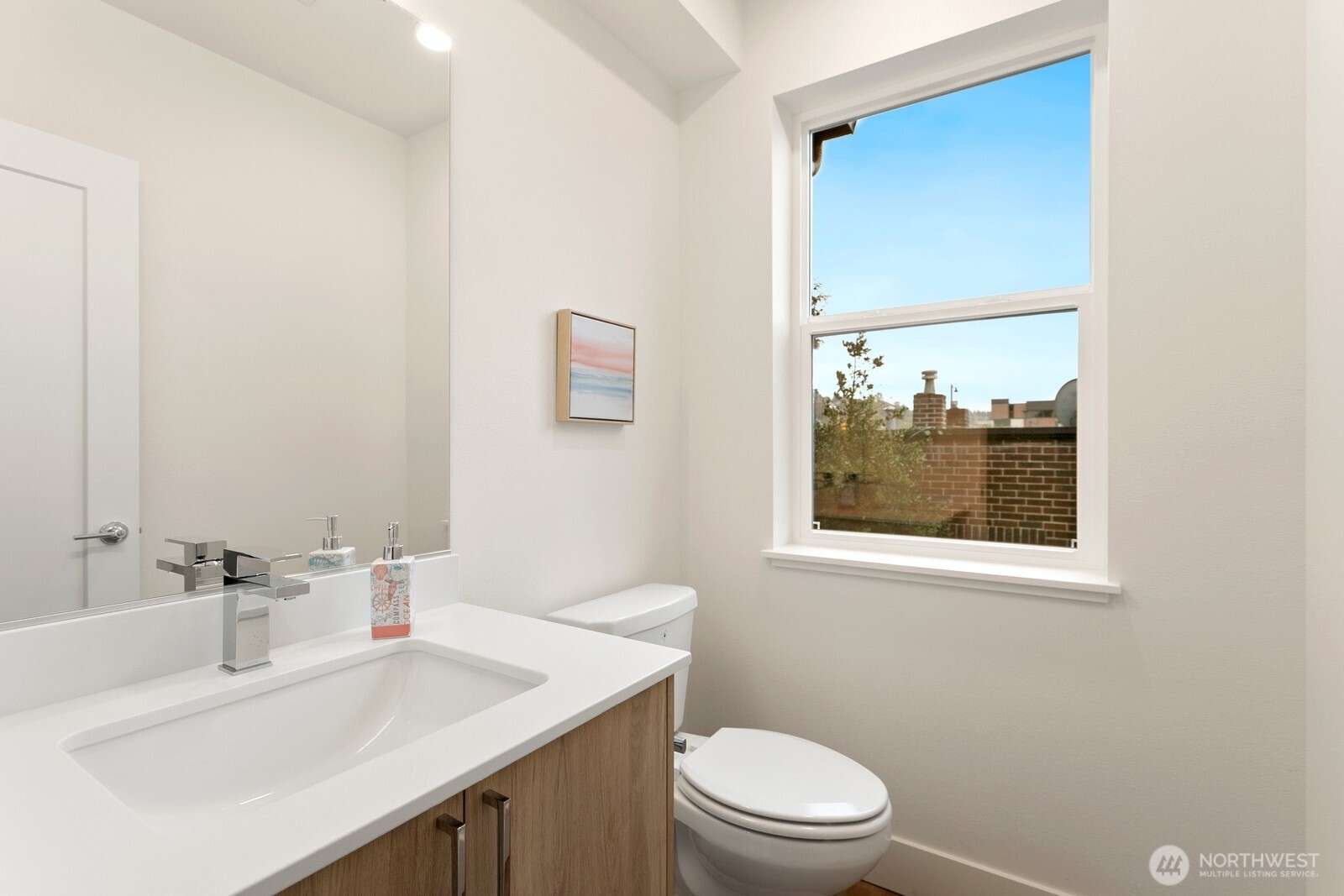 117 Wells Avenue South, Unit B Renton, WA 98057 - Photo 13 of 26 a bathroom with a sink a toilet and a mirror