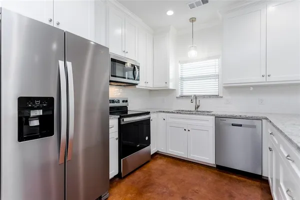 a kitchen with granite countertop white cabinets and black appliances