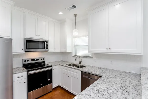 a kitchen with stainless steel appliances granite countertop a refrigerator stove and microwave