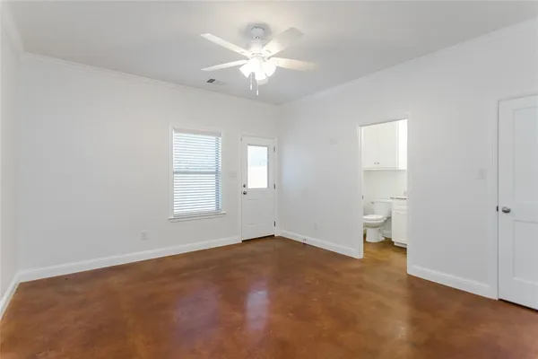 an empty room with wooden floor and ceiling fan
