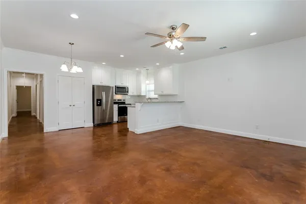 an empty room with a window and a ceiling fan
