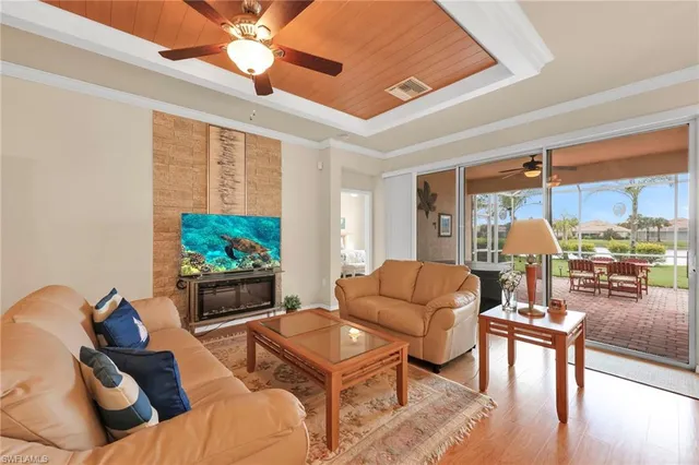 a living room with furniture a flat screen tv and a large window