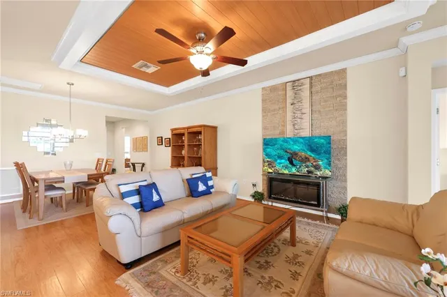 a living room with furniture a chandelier and a flat screen tv