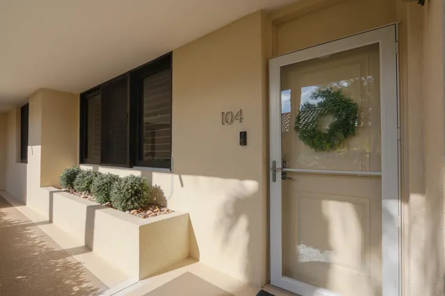 a front view of a building with cars parked