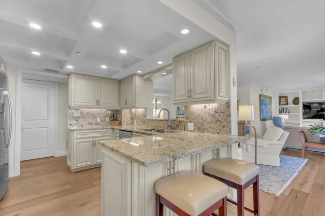 a kitchen with a dining table chairs and wooden floor