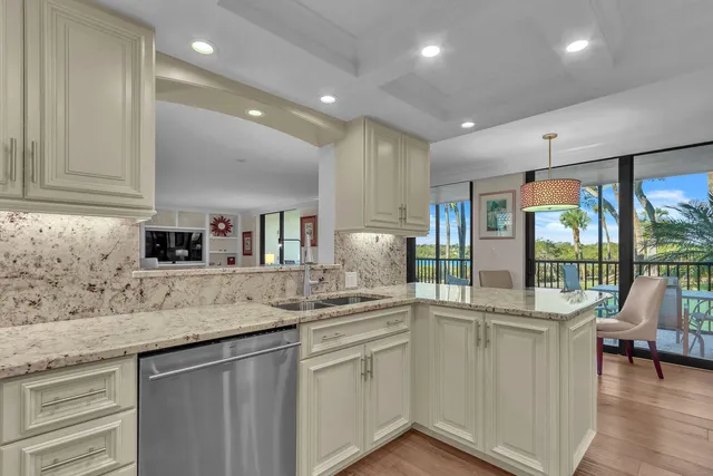 a kitchen with granite countertop a sink and white cabinets