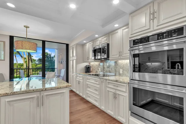 a kitchen with stainless steel appliances granite countertop a stove and cabinets