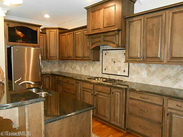5808 Bison Drive Oak Ridge, NC 27310 - Photo 7 of 16 Kitchen. Granite counter tops. Tile back splash. Cook top. Island!