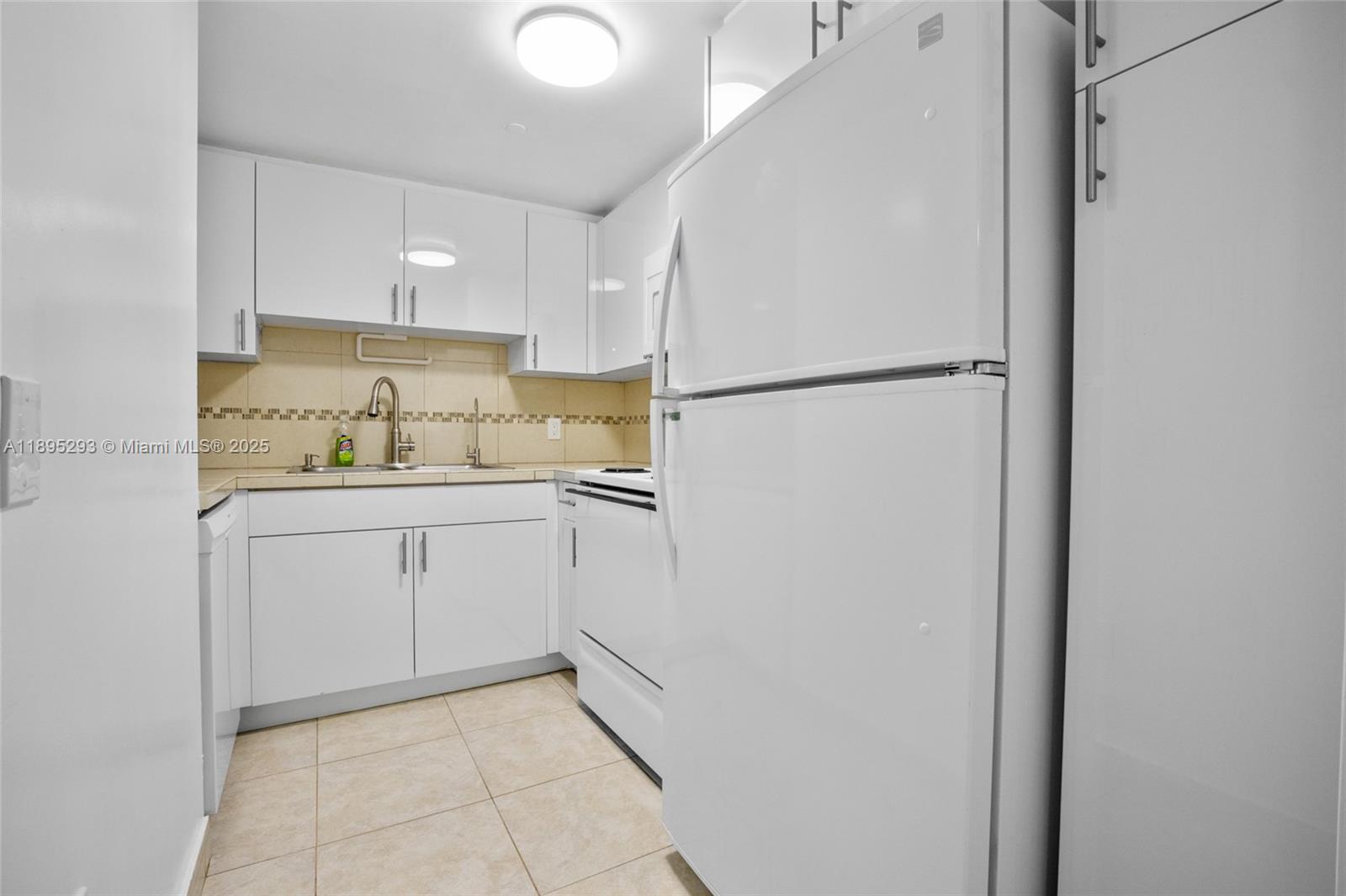 1060 Northwest 7th Street, Unit 106 Miami, FL 33136 - Photo 11 of 26 a kitchen with a refrigerator sink and cabinets
