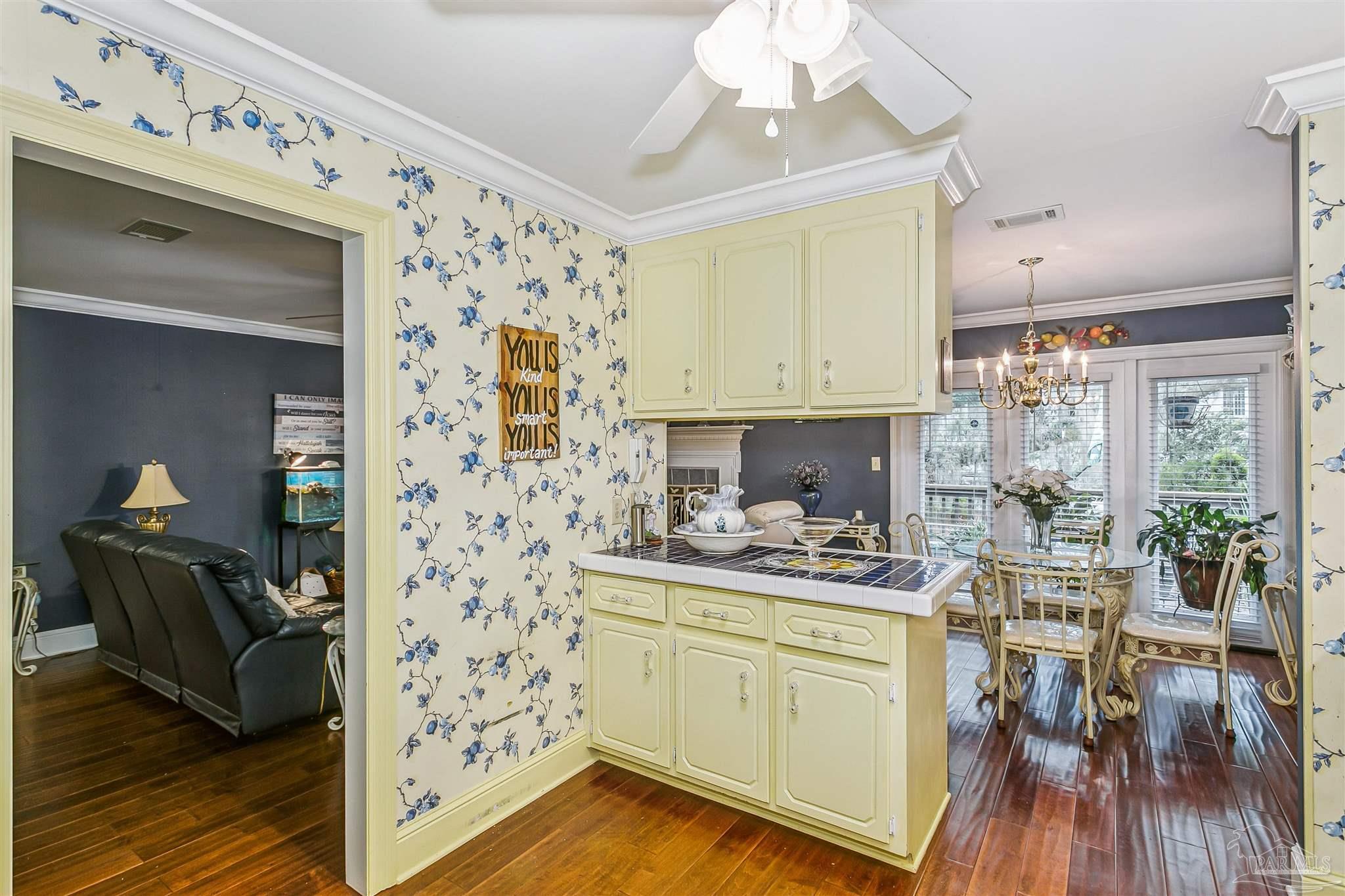 4831 East Olive Road, Unit 2D Pensacola, FL 32514 - Photo 17 of 29 a kitchen with a sink dishwasher a stove and a dining table with wooden floor