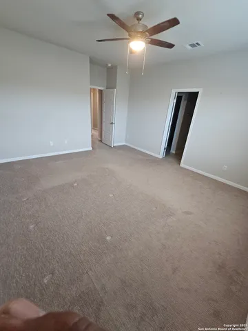 an empty room with closet and fan