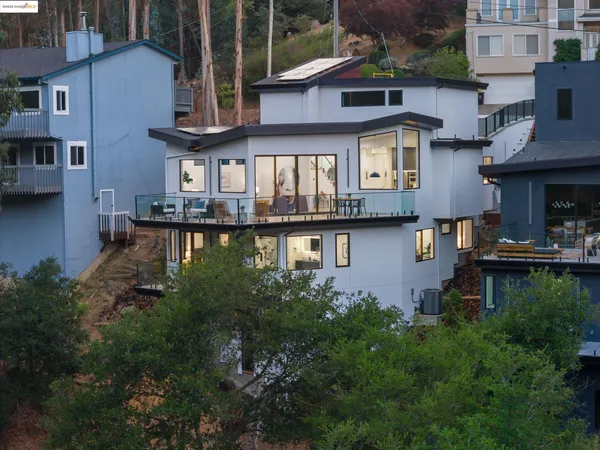 a front view of a house with lots of green space and lake view