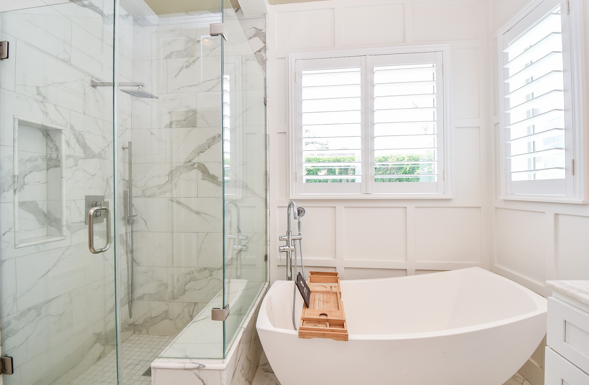263 Wood Loop Street Houston, TX 77015 - Photo 31 of 45 This bathroom features a luxurious freestanding bathtub and a spacious glass-enclosed shower with elegant marble tile. The room is bright and airy, thanks to large windows with plantation shutters.