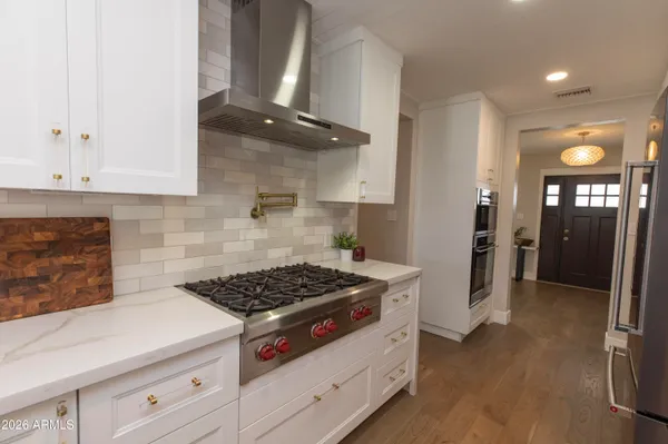 a kitchen with granite countertop a stove and cabinets