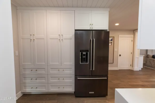 a view of kitchen with refrigerator and cabinet